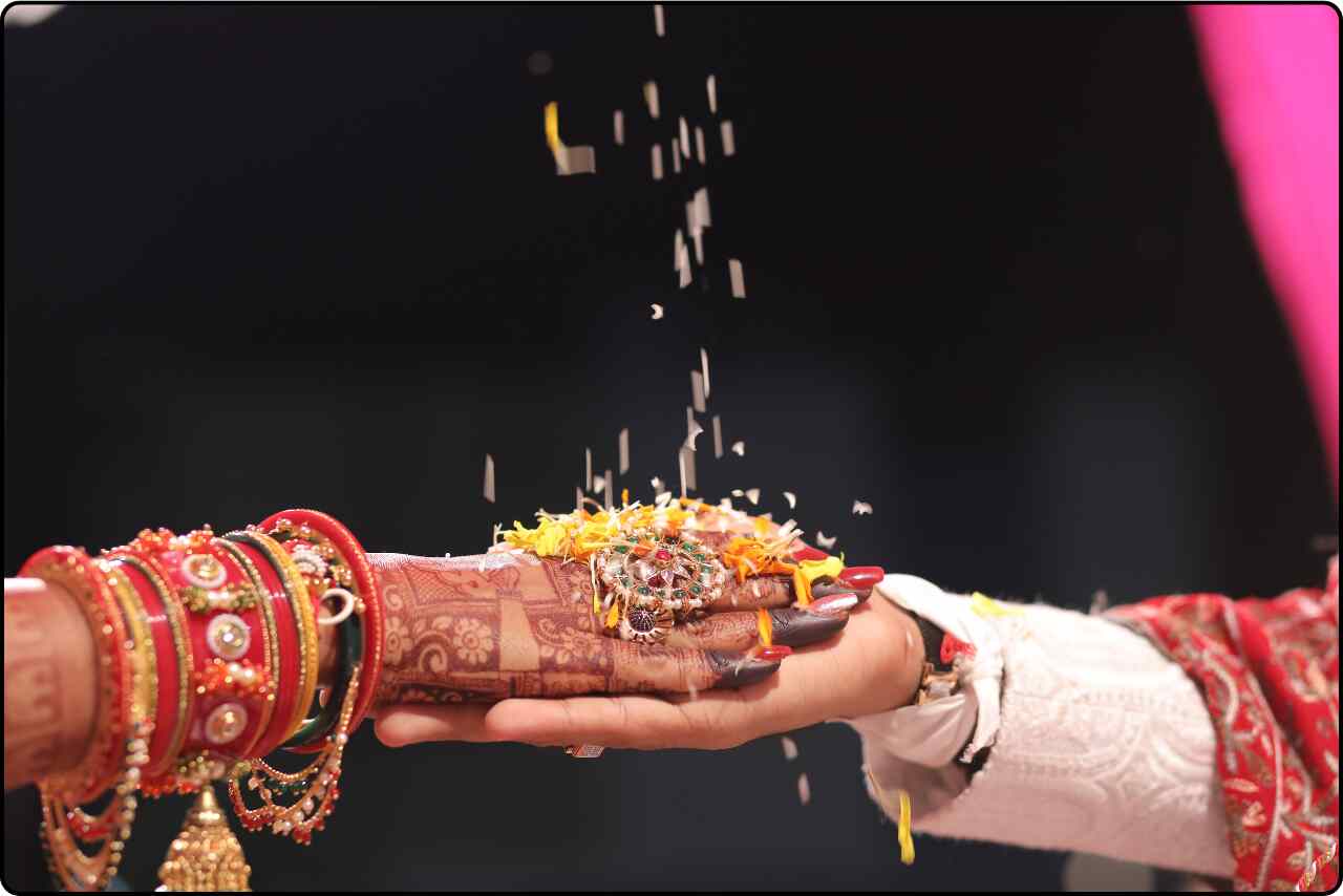 Bride and groom's hands joined together, symbolizing unity and love in a traditional wedding.